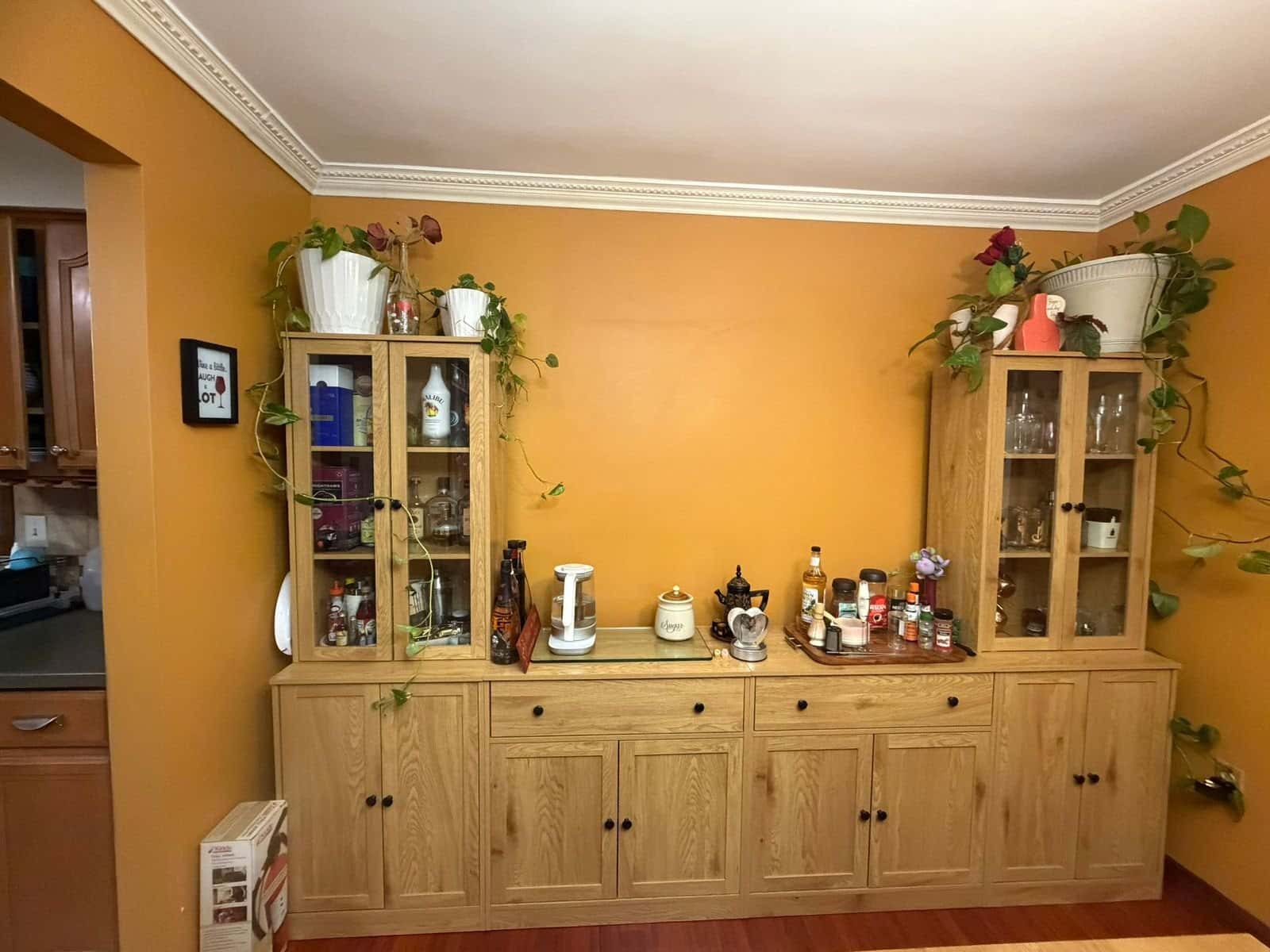 China cabinet and hutch decorated with plants and dishes in a dining room, customer's photo