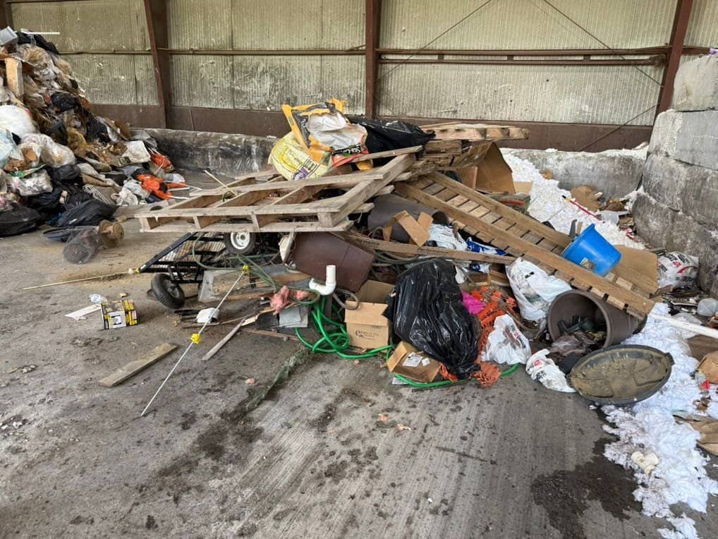 Load of junk and debris dumped on the floor of a transfer station for sorting